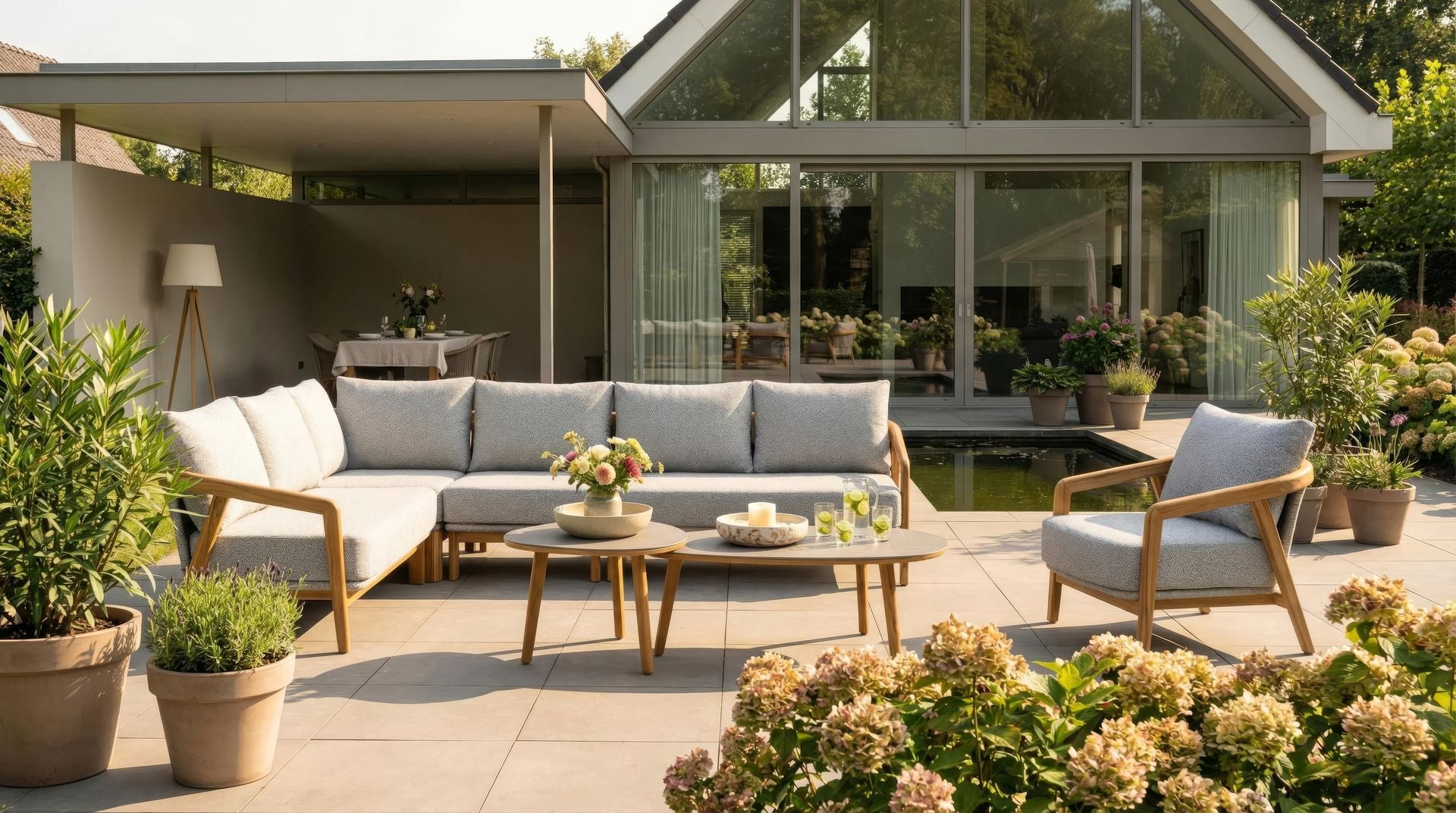 Bella Eck-Gartenlounge aus massivem Teakholz mit hellgrauen Outdoor-Polstern und Couchtischen mit Sinterstone-Tischplatten