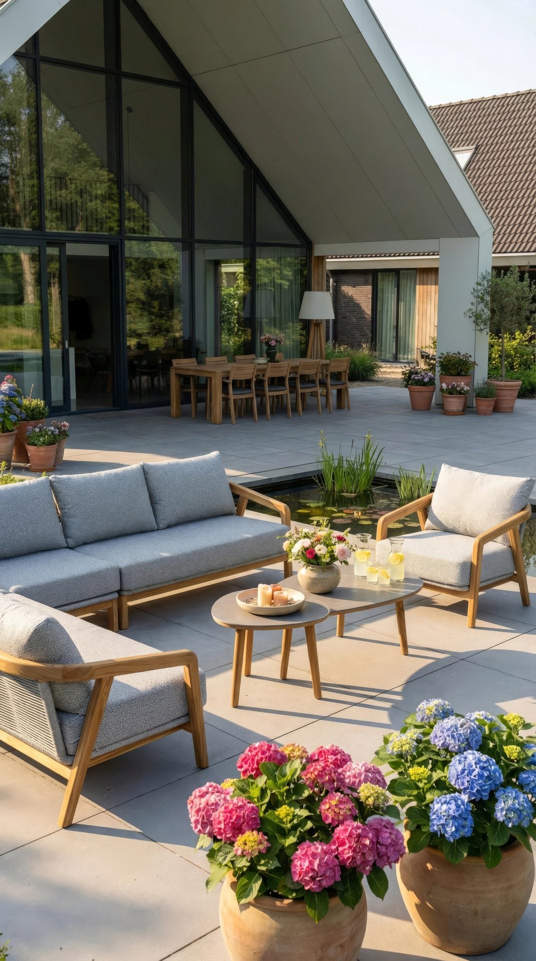 Bella Eck-Gartenlounge aus massivem Teakholz mit hellgrauen Outdoor-Polstern und Couchtischen mit Sinterstone-Tischplatten