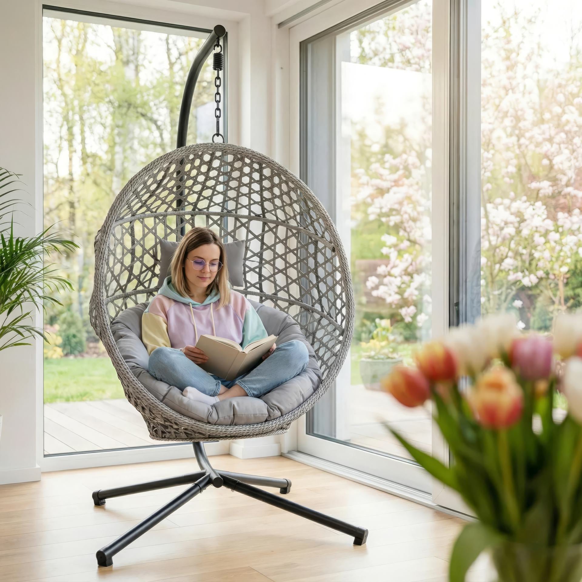 Hängekorb Cleo mit schwarzem Gestell, grauem Kunststoffgeflecht & grauen Polstern – zusammenklappbar & wetterfest.