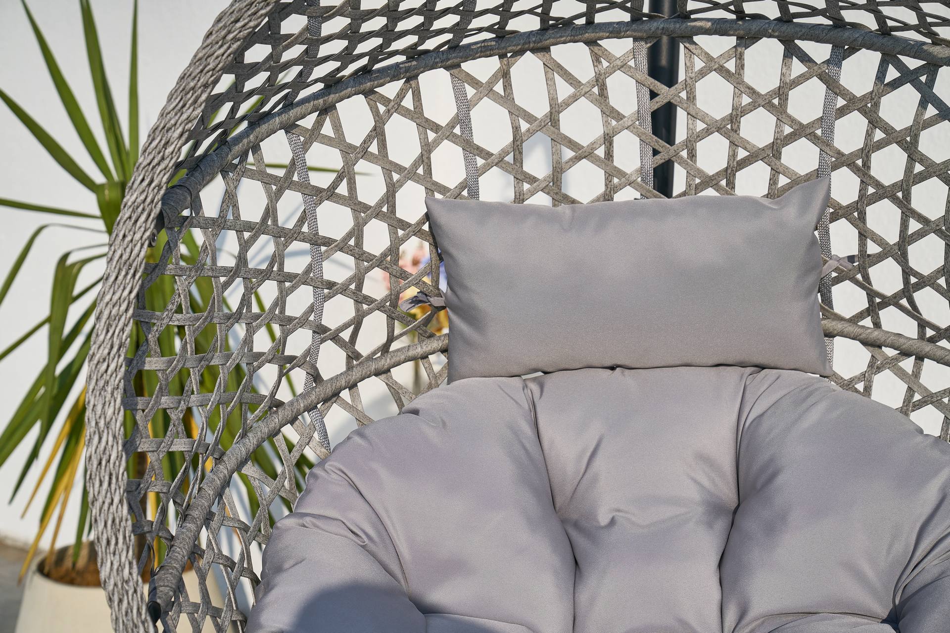 Hängekorb Cleo mit schwarzem Gestell, grauem Kunststoffgeflecht & grauen Polstern – zusammenklappbar & wetterfest.