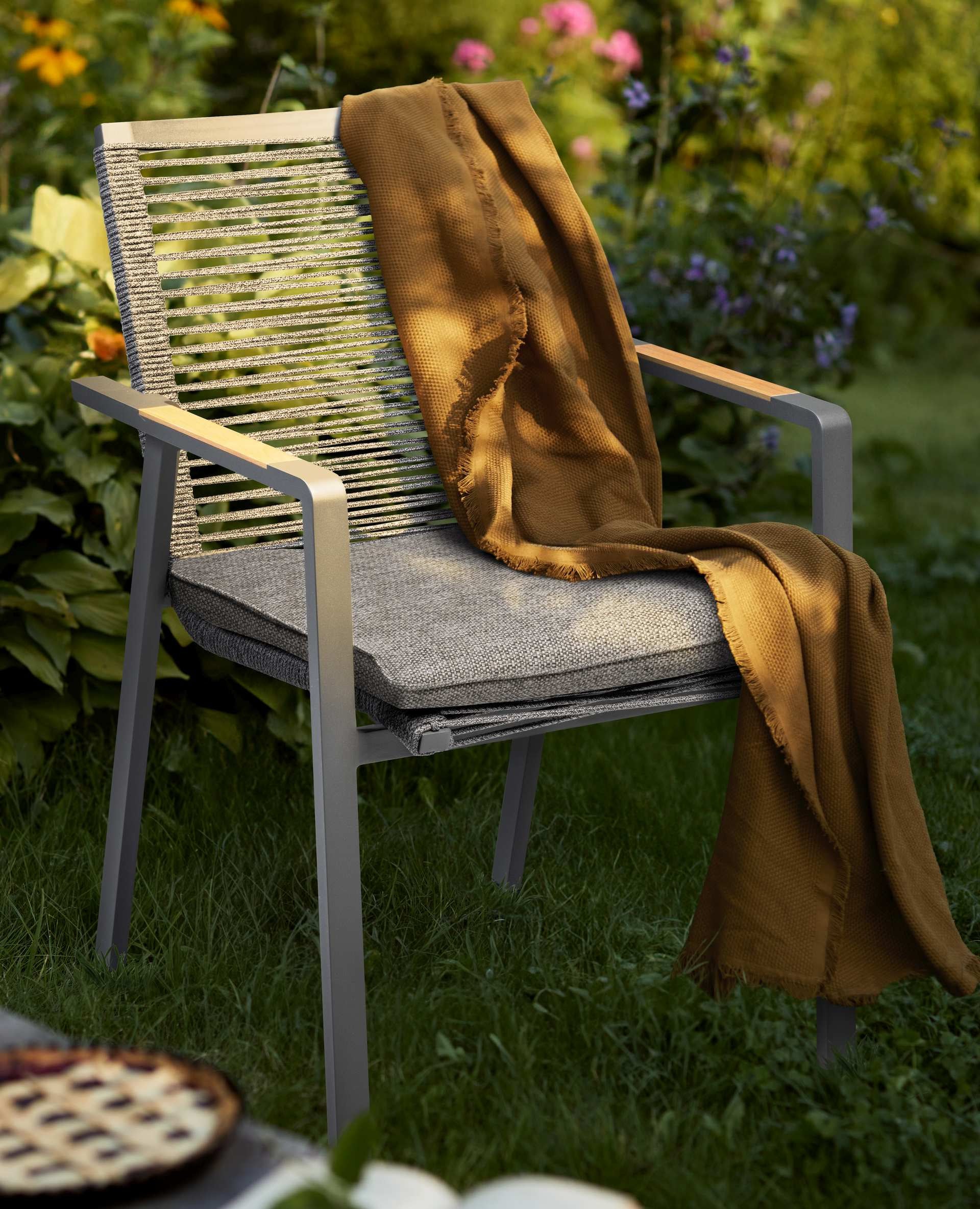 Armstuhl Wayne mit Aluminiumgestell in Anthrazit, grauen Schnüren, und dunkelgrauem Kissen, stapelbar und wetterfest.