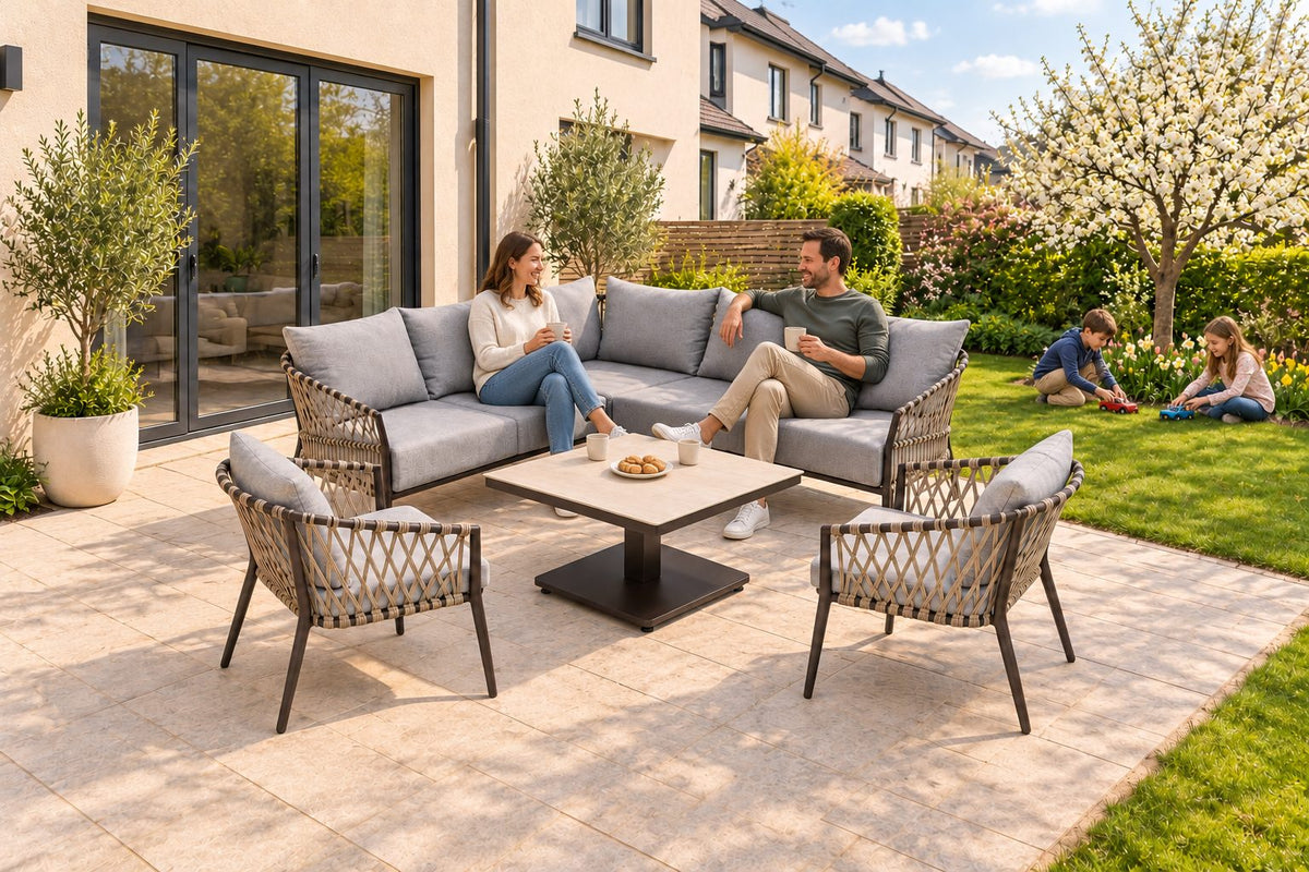 Amelie Eckbankgruppe mit zwei Armstühlen und beigem Sinterstone-Tisch im Garten