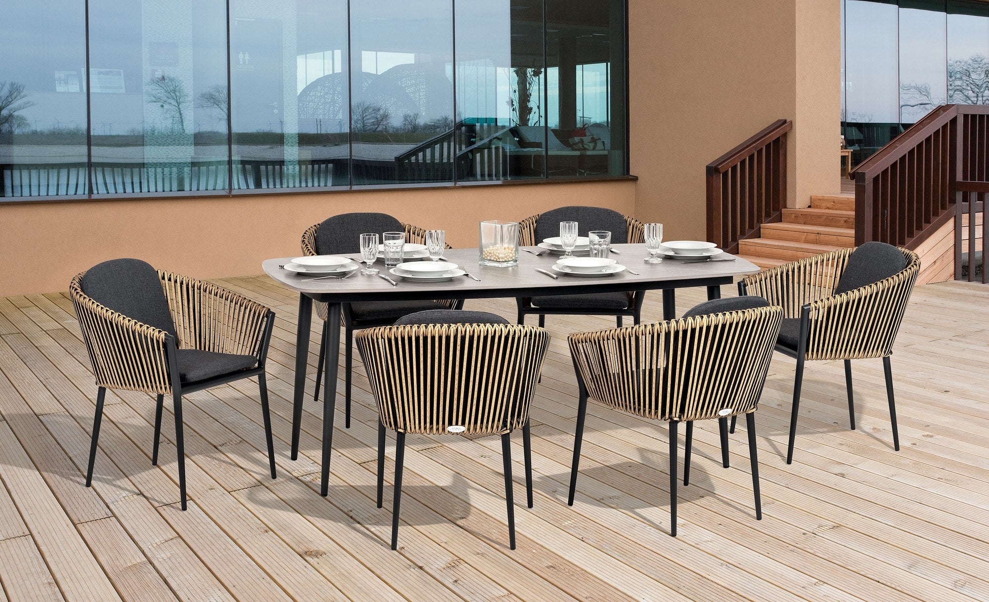 Gartenstuhl Bradley mit Aluminiumgestell in Anthrazit, Kunststoffbändern in Natur und wetterfesten dunkelgrauen Kissen.