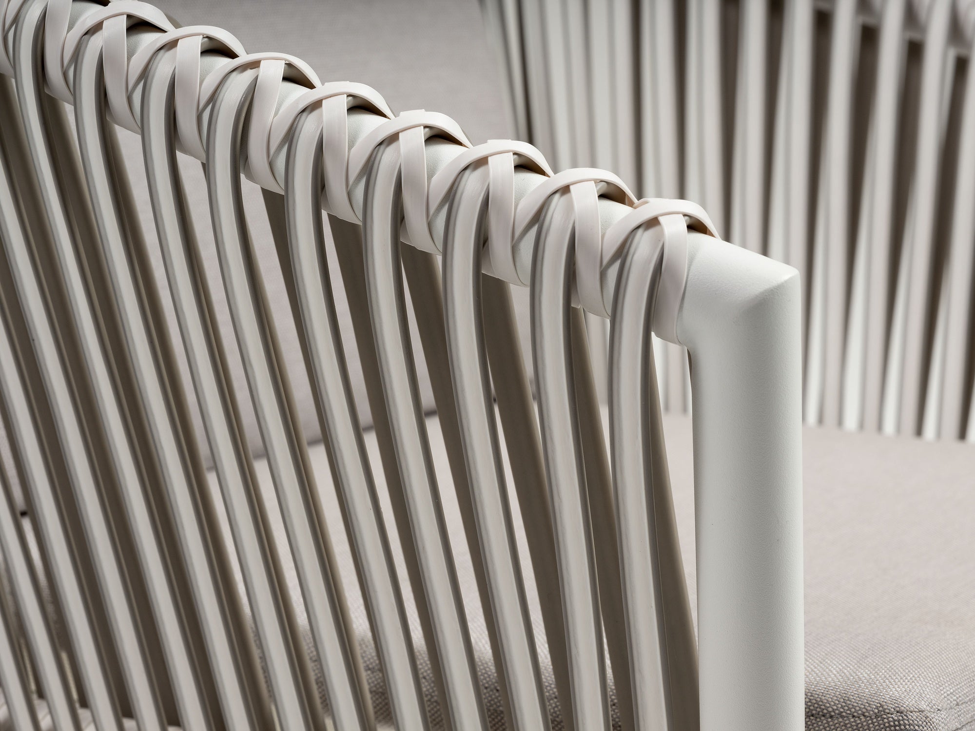 Gartenstuhl Bradley mit Aluminiumgestell in Weiß, Kunststoffbändern in Weiß und wetterfesten hellgrauen Kissen.