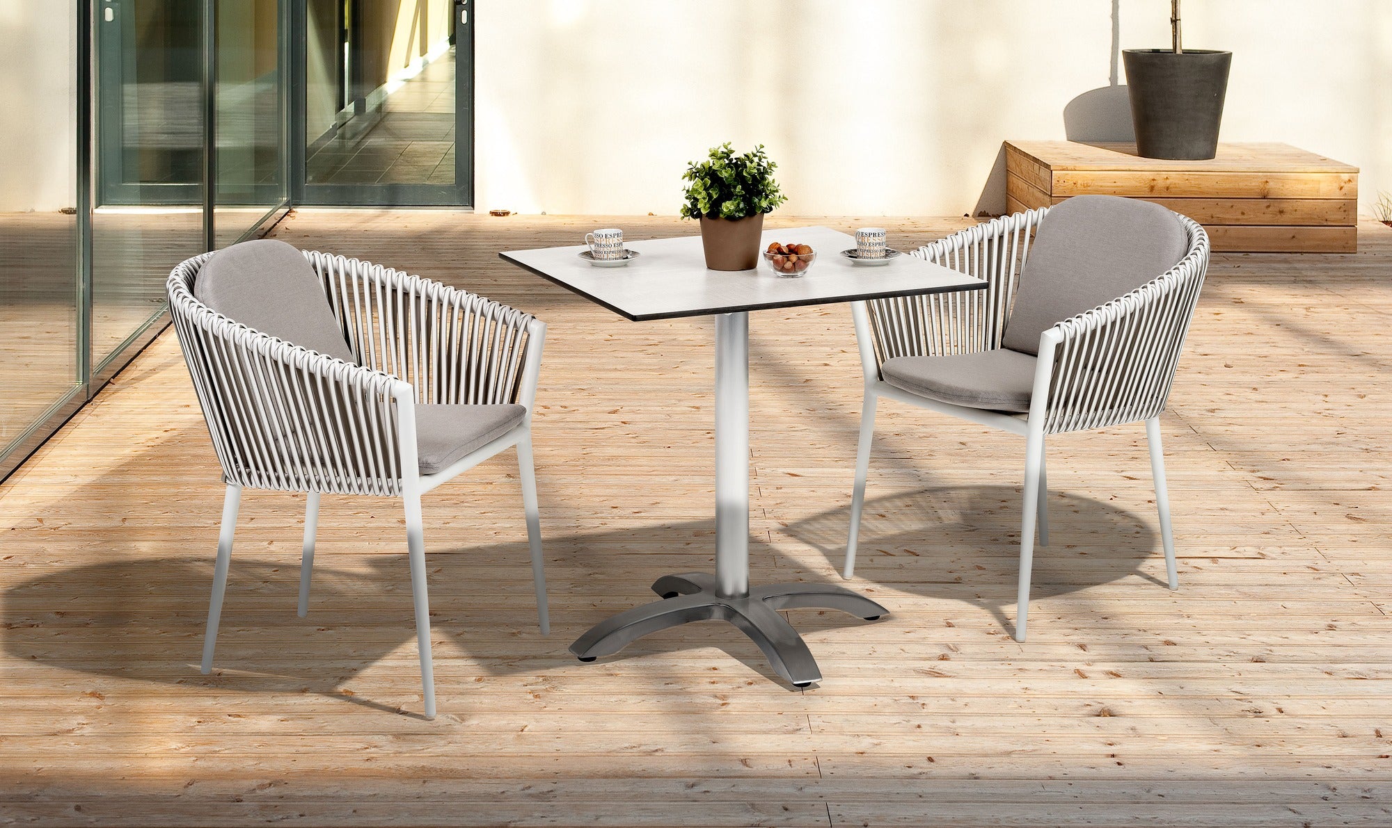 Gartenstuhl Bradley mit Aluminiumgestell in Weiß, Kunststoffbändern in Weiß und wetterfesten hellgrauen Kissen.