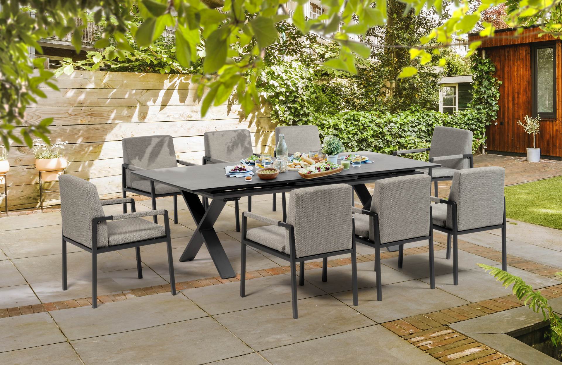 Tischgruppe Mia mit ausziehbarem Tisch und 8 grauen Stühlen im Garten.