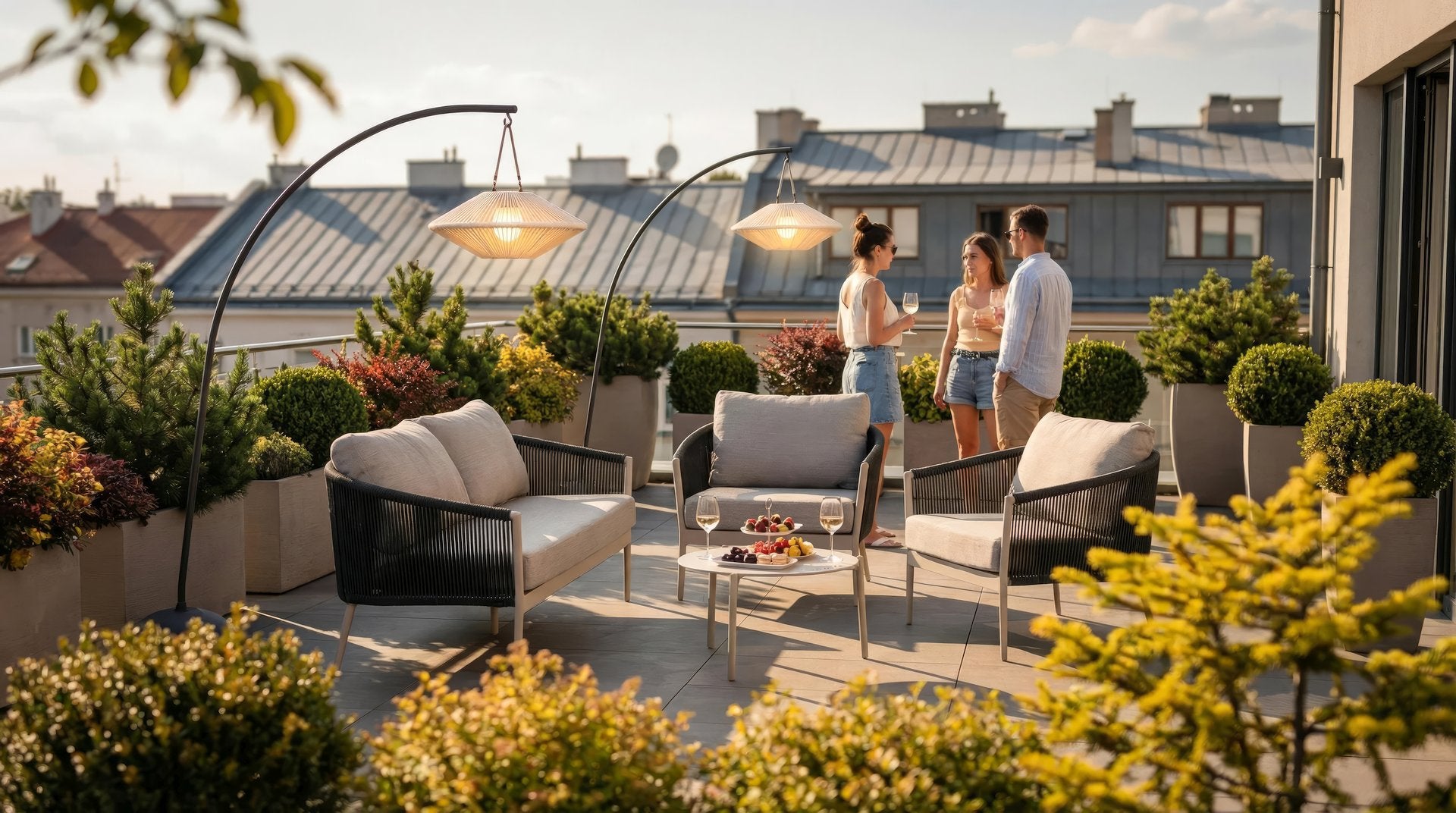 Gartenlounge Michelle in Anthrazit mit hellgrauen Kissen, bestehend aus einer Bank, zwei Fauteuils und zwei Couchtischen.