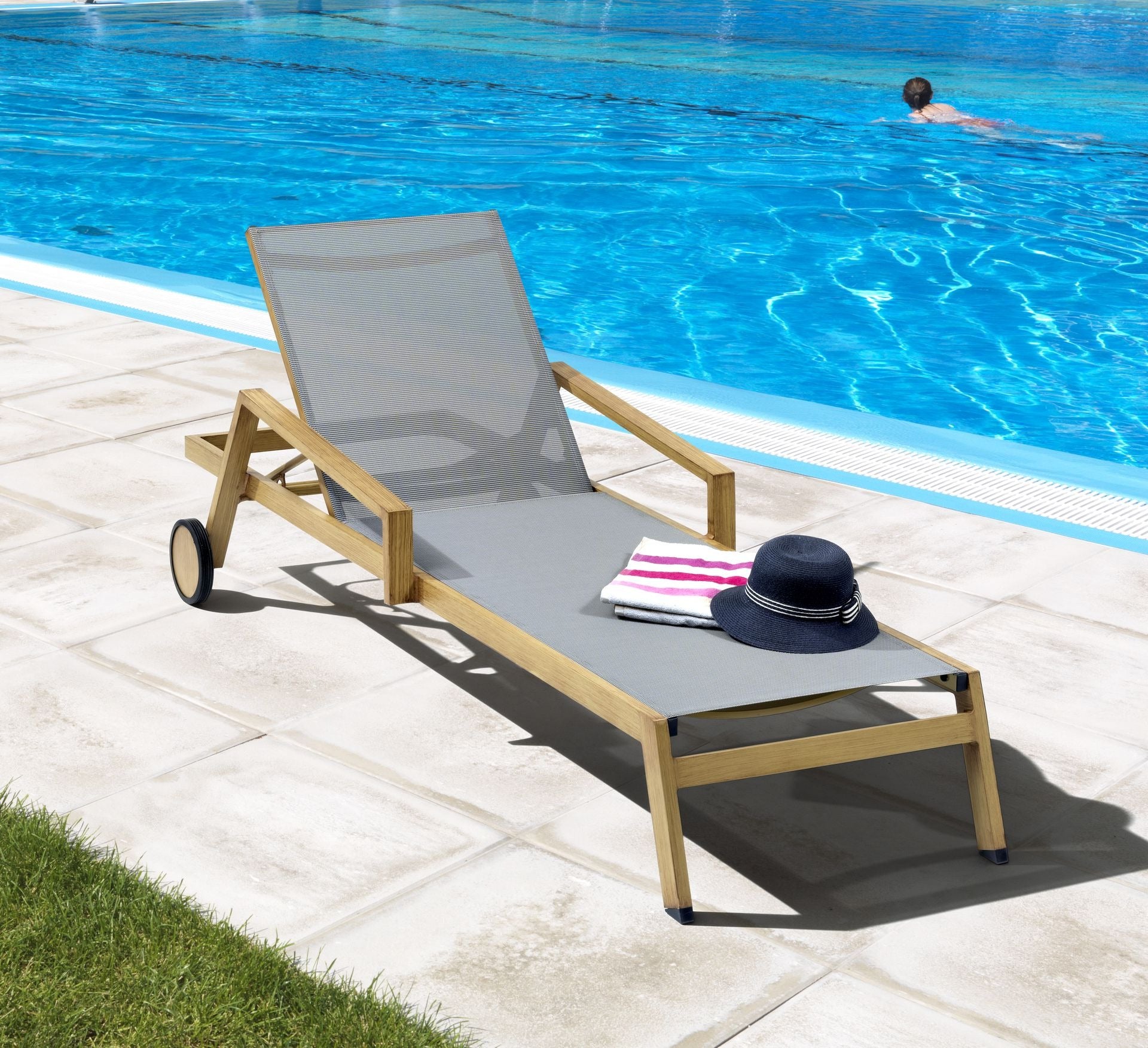 Die Sonnenliege Rocco-Wood mit Aluminiumgestell in Holzoptik und taupe-grauer Textilenbespannung, verstellbarer Rückenlehne und Rollen von Gartenmöbelshop.at.